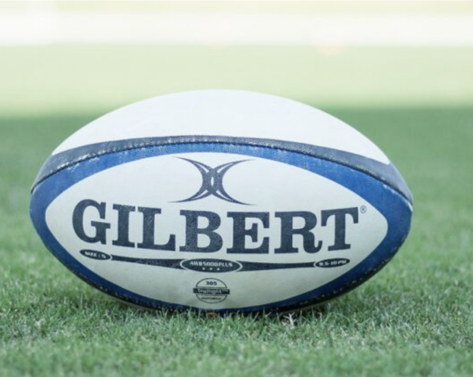 A white and blue rugby pall on green grass